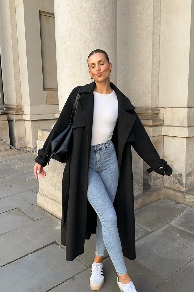 Black Long Coat + White Fitted Top + Light Blue Skinny Jeans + White Sneakers + Black Shoulder Bag