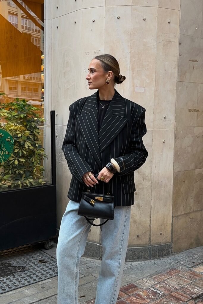 Black Pinstripe Blazer + Black Top + Light Blue Jeans + Black Mini Handbag + Gold Jewelry + Sunglasses
