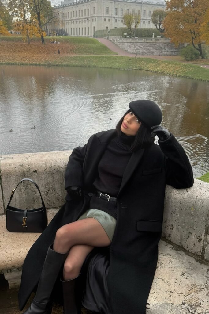 Black Turtleneck + Black Long Coat + Sage Green Mini Skirt + Black Knee-High Boots + Black Beret