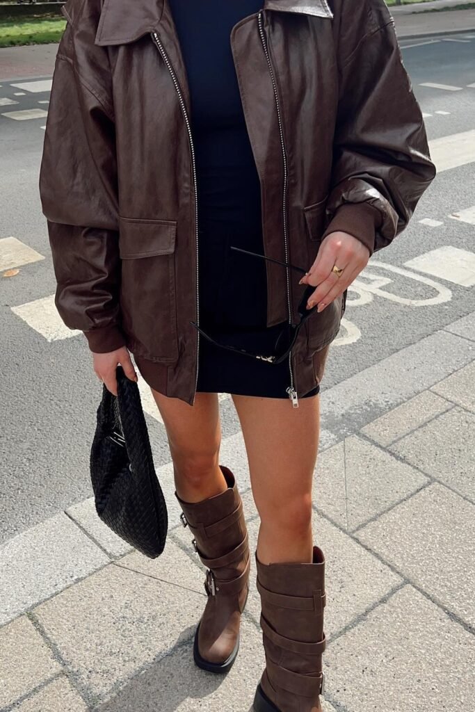 Brown Faux Leather Bomber Jacket + Black Mini Dress + Brown Buckled Combat Boots + Black Woven Handbag