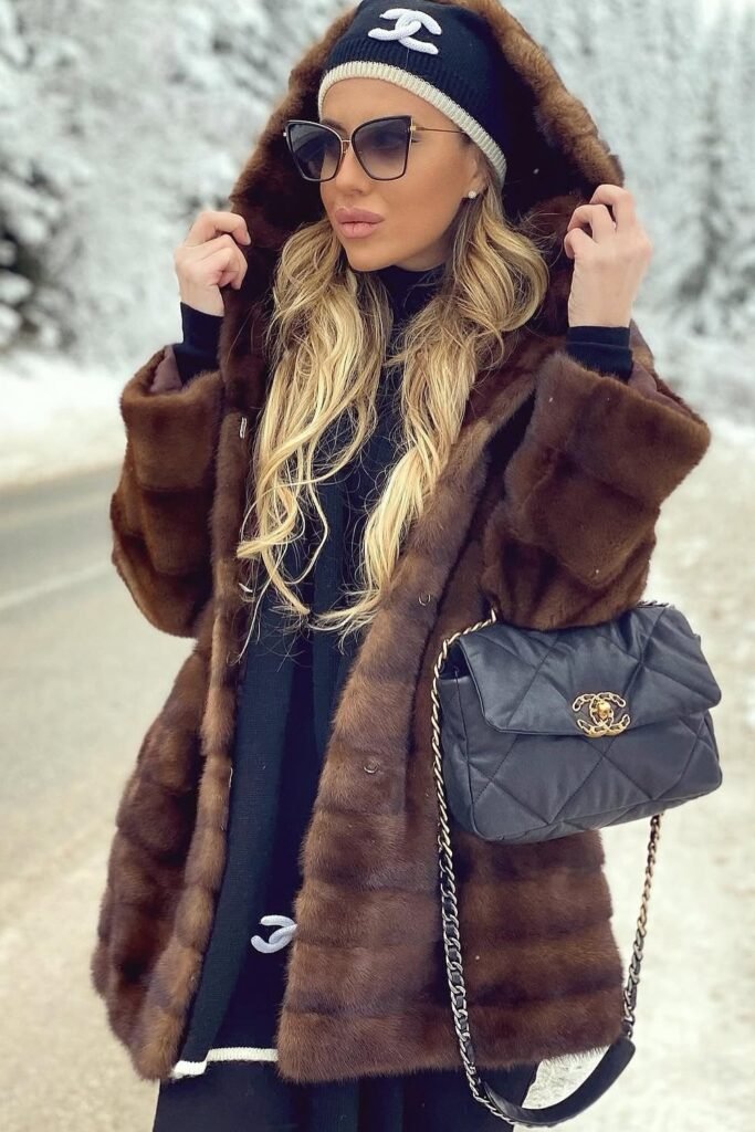 Brown Fur Hooded Coat + Black Ribbed Knit Dress/Top + Black and White Logo Beanie + Black Quilted Crossbody Bag