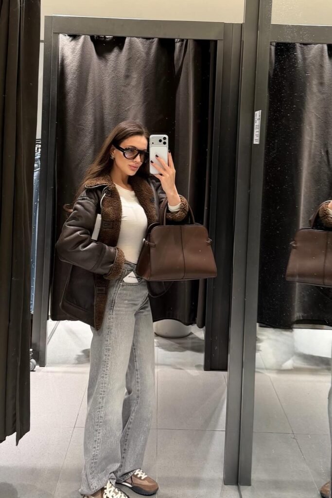 Brown Shearling Aviator Jacket + White Top + Grey Wide-Leg Jeans + Brown and White Sneakers