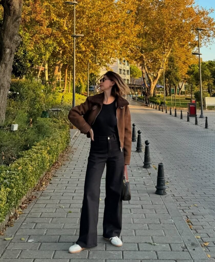 Brown Shearling-Lined Jacket + Black Knit Top + Black Wide-Leg Jeans + White Sneakers