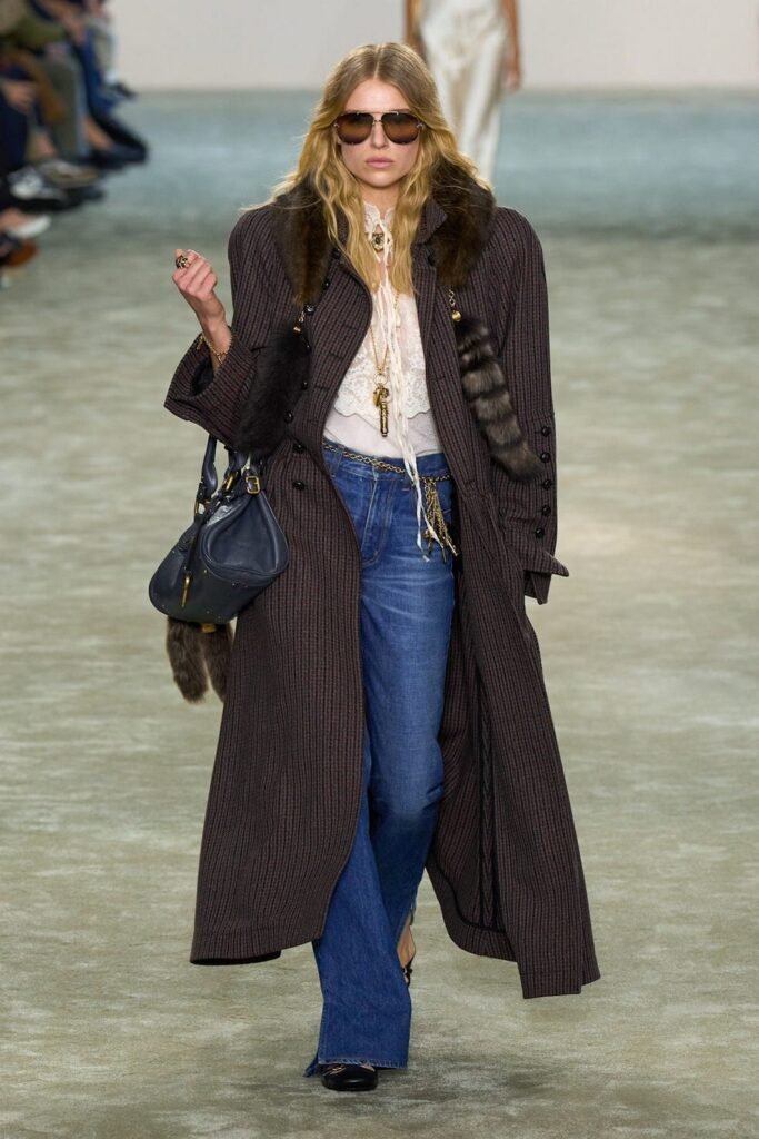 Brown Striped Long Coat with Fur Accents + White Blouse + Blue Flared Jeans + Black Handbag