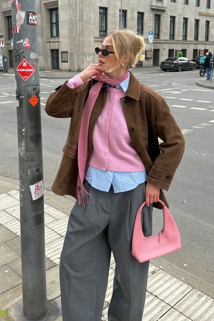 Brown Suede Jacket + Pink Cardigan + Light Blue Button-Down Shirt + Grey Wide-Leg Trousers + Pink Scarf and Handbag