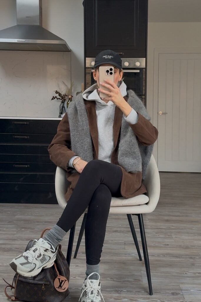 Brown Suede-Look Jacket + Grey Hoodie + Black Leggings + White/Grey Sneakers + Black Cap