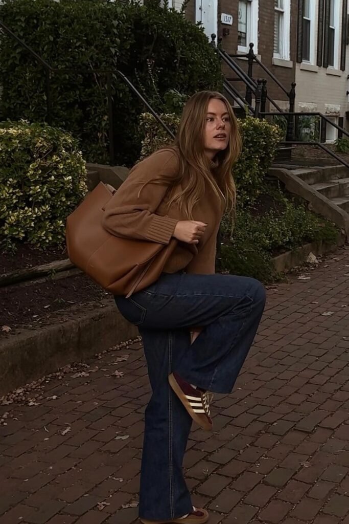 Brown Turtleneck Sweater + Dark Wash Flared Jeans + Maroon and Gold Sneakers + Brown Leather Tote Bag