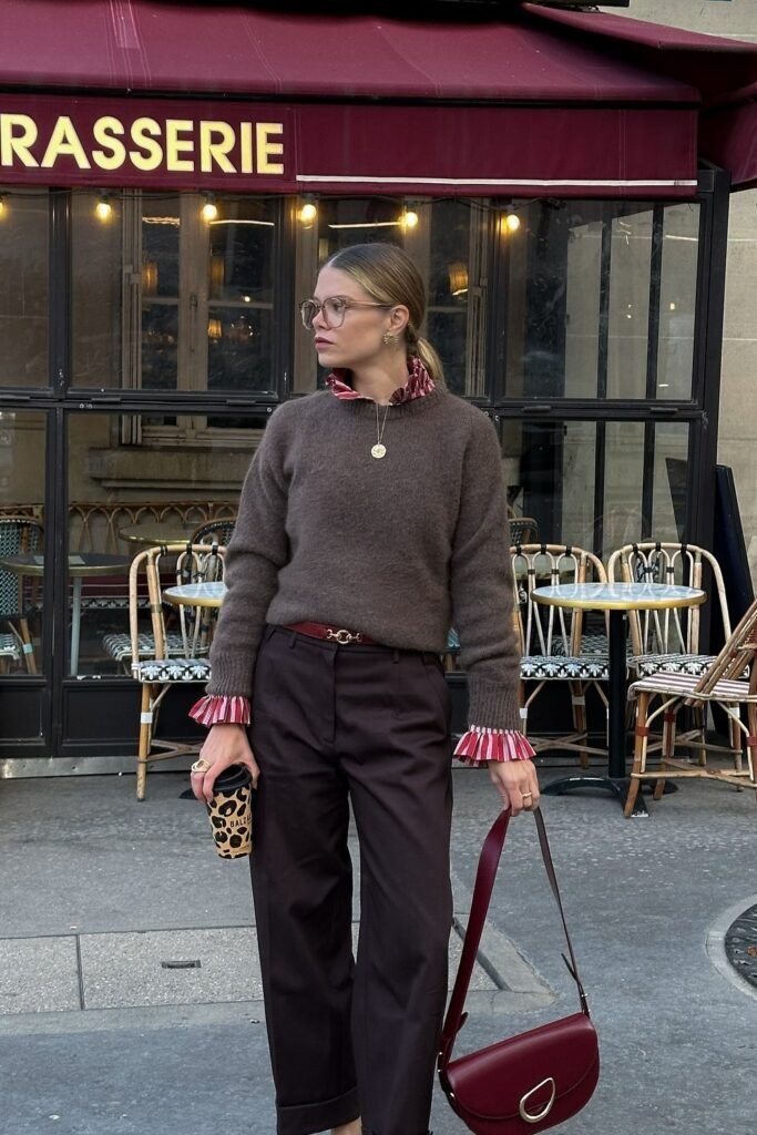 Brown Wool Sweater + Red and White Ruffle-Neck Blouse + Dark Brown Trousers + Red Belt + Burgundy Saddle Bag