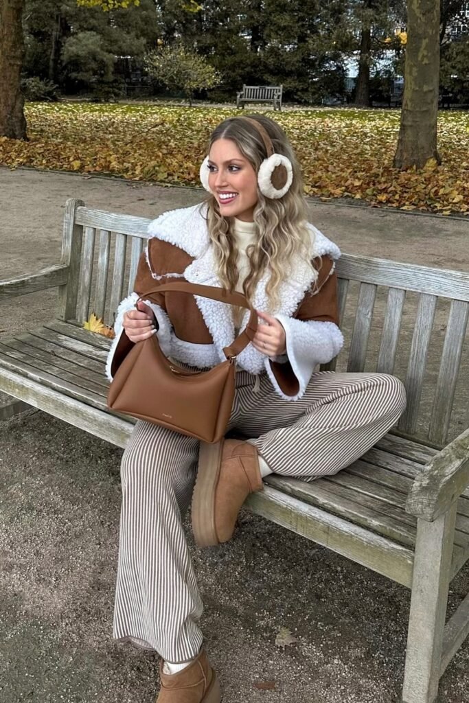 Brown and White Shearling-Lined Aviator Jacket + White Turtleneck + Tan and White Pinstripe Trousers + Tan Platform Boots + Shearling Earmuffs