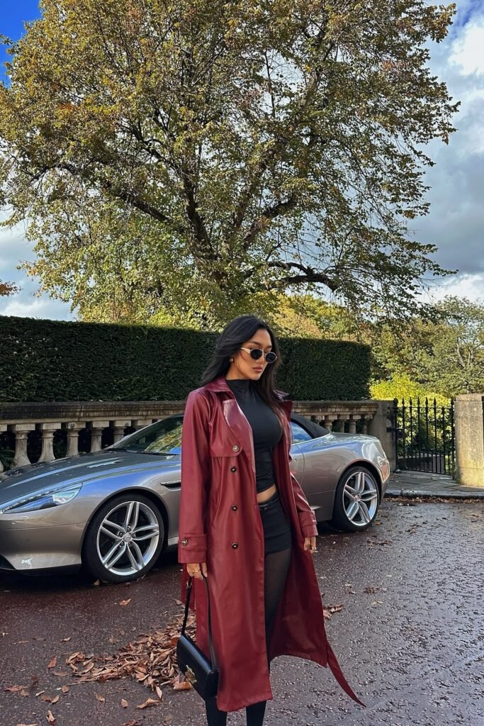 Burgundy Leather Trench Coat + Black Fitted Top + Black Mini Skirt + Sheer Black Tights + Black Shoulder Bag + Round Sunglasses