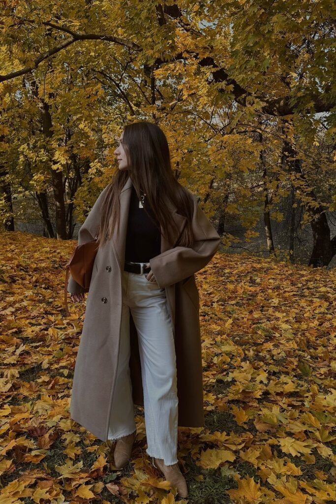 Camel Long Coat + Black Turtleneck + White Wide-Leg Jeans + Black Belt + Tan Suede Ankle Boots