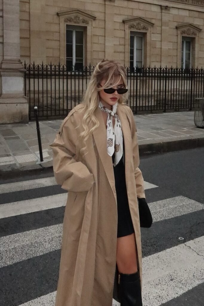 Camel Trench Coat + Black Dress/Romper + White Silk Scarf + Black Knee-High Boots