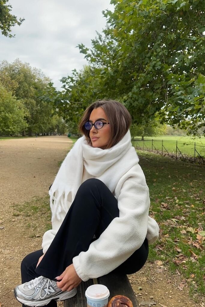 Cream Fleece Pullover + Chunky White Scarf + Black Flared Trousers + Athletic Sneakers