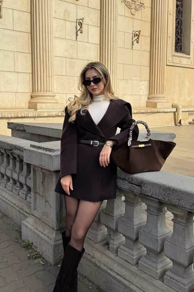 Dark Brown Belted Coat Dress + Cream Turtleneck Top + Black Sheer Tights + Brown Knee-High Boots + Brown Handbag + Black Sunglasses