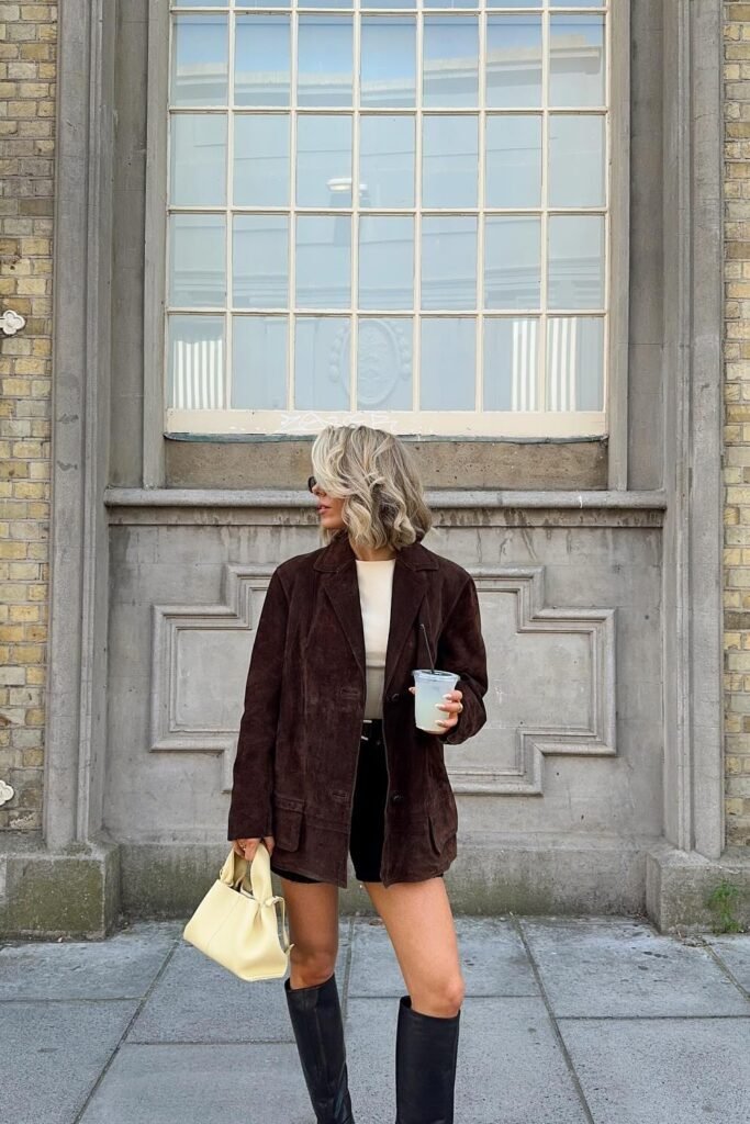Dark Brown Suede Blazer + Cream Crop Top + Black Shorts + Black Knee-High Boots + Pale Yellow Handbag