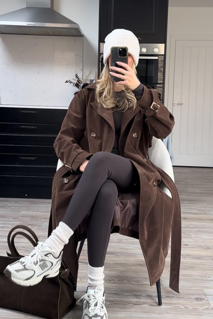 Dark Brown Suede-Look Trench Coat + Black Top + Dark Brown Leggings + White Beanie + Brown/White Sneakers