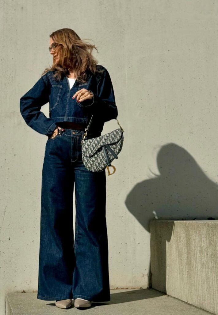 Dark Denim Cropped Jacket + Dark Denim High-Waisted Flared Jeans + White Top (peeking out) + Nude Pointed Flats + Patterned Dior Saddle Bag
