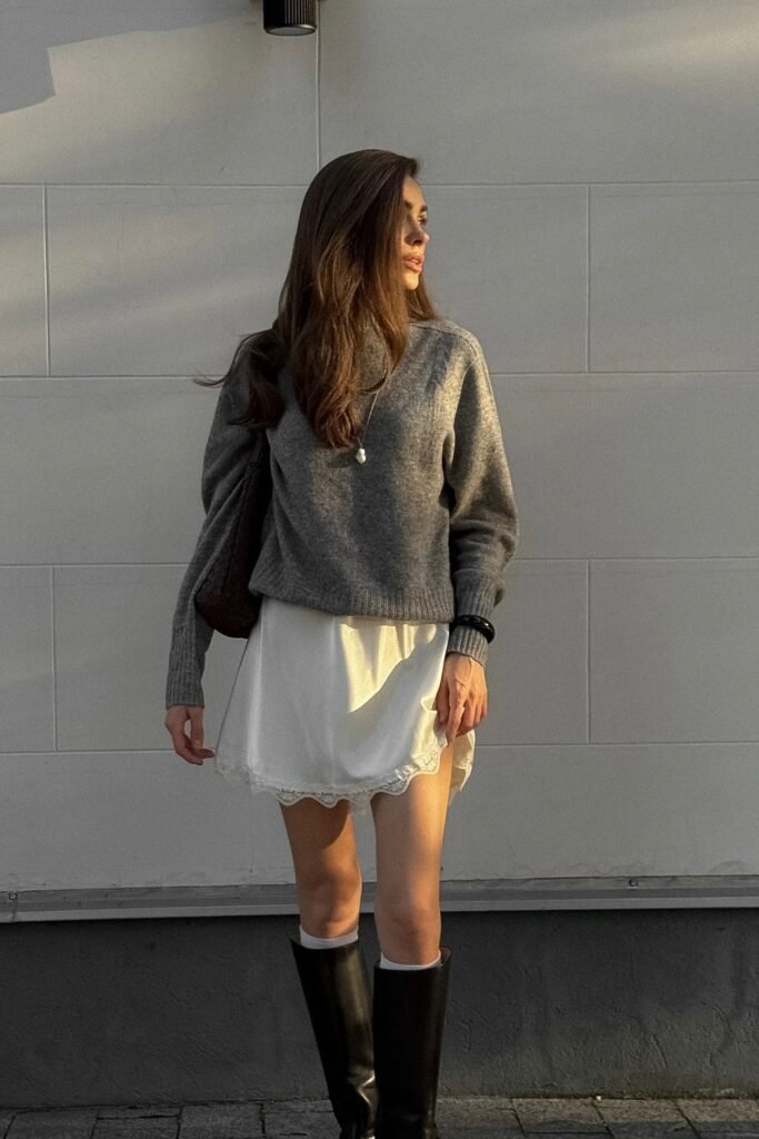 Grey Knit Sweater + White Satin Mini Dress + Black Knee-High Boots + Silver Pendant Necklace