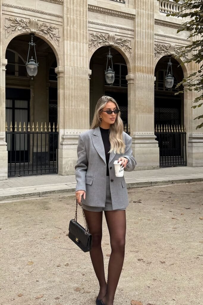 Grey Oversized Blazer + Black Top + Grey Shorts + Sheer Black Tights + Black Handbag