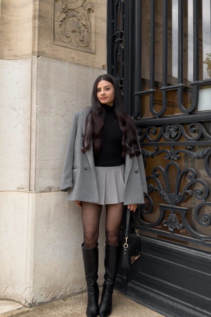 Grey Oversized Blazer + Black Turtleneck Sweater + Grey Pleated Mini Skirt + Black Tights + Black Knee-High Boots