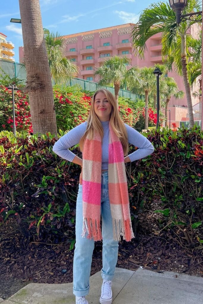 Light Blue Long-Sleeve Top + Pink/Orange Striped Scarf + Light Wash Straight Jeans + White Sneakers