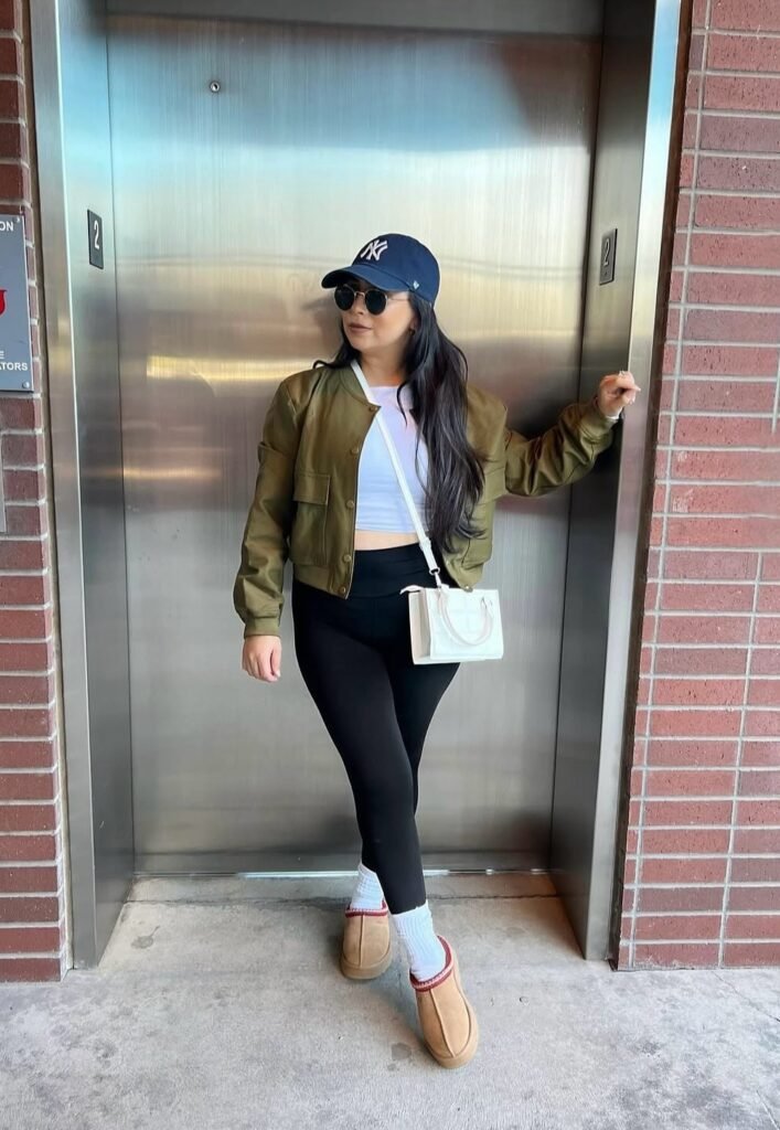 Olive Bomber Jacket + White Crop Top + Black Leggings + Tan Slippers + Navy Cap + White Crossbody Bag