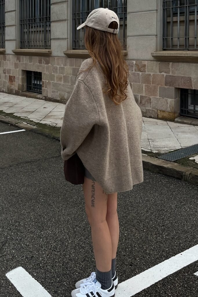 Oversized Beige Sweater + Grey Mini Skirt + Beige Baseball Cap + Grey Socks + White and Black Sneakers