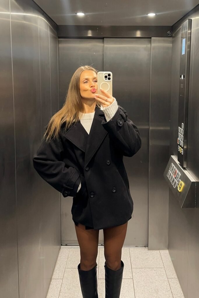 Oversized Black Peacoat + White Sweater + Black Knee-High Boots