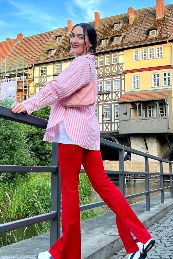 Pink and White Striped Oversized Button-Down Shirt + White Undershirt + Red Flared Trousers with Slits + Sneakers