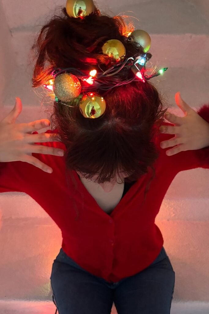 Red V-Neck Cardigan + Dark Jeans + Hair Styled with Christmas Lights and Ornaments