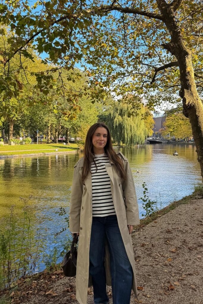 Striped Sweater + Khaki Trench Coat + Wide-Leg Denim Jeans + Dark Brown Bag