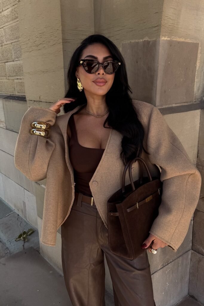 Tan Cropped V-Neck Jacket + Brown Scoop-Neck Top + Dark Brown Faux Leather Trousers + Dark Brown Suede Tote Bag + Gold Cuff Bracelets