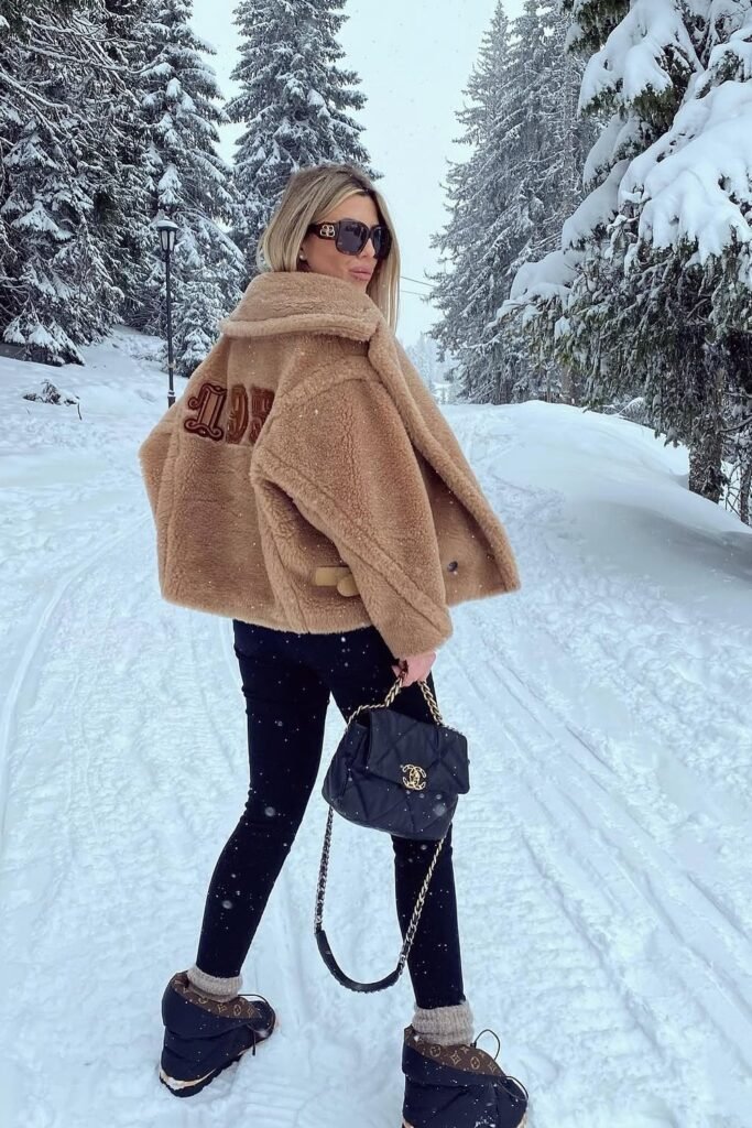Tan Teddy Fleece Bomber Jacket with Logo + Black Skinny Jeans/Leggings + Black and Brown Snow Boots + Black Quilted Handbag
