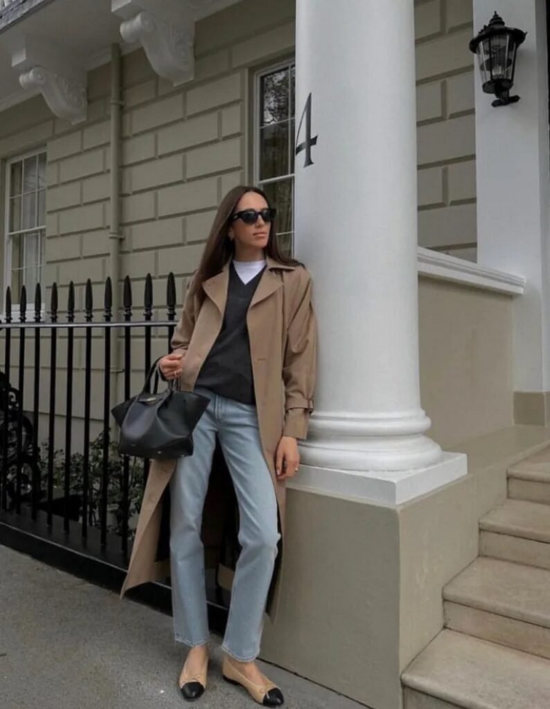 Tan Trench Coat + Dark Grey V-Neck Sweater + White T-Shirt + Light Wash Straight Jeans + Two-Tone Flats