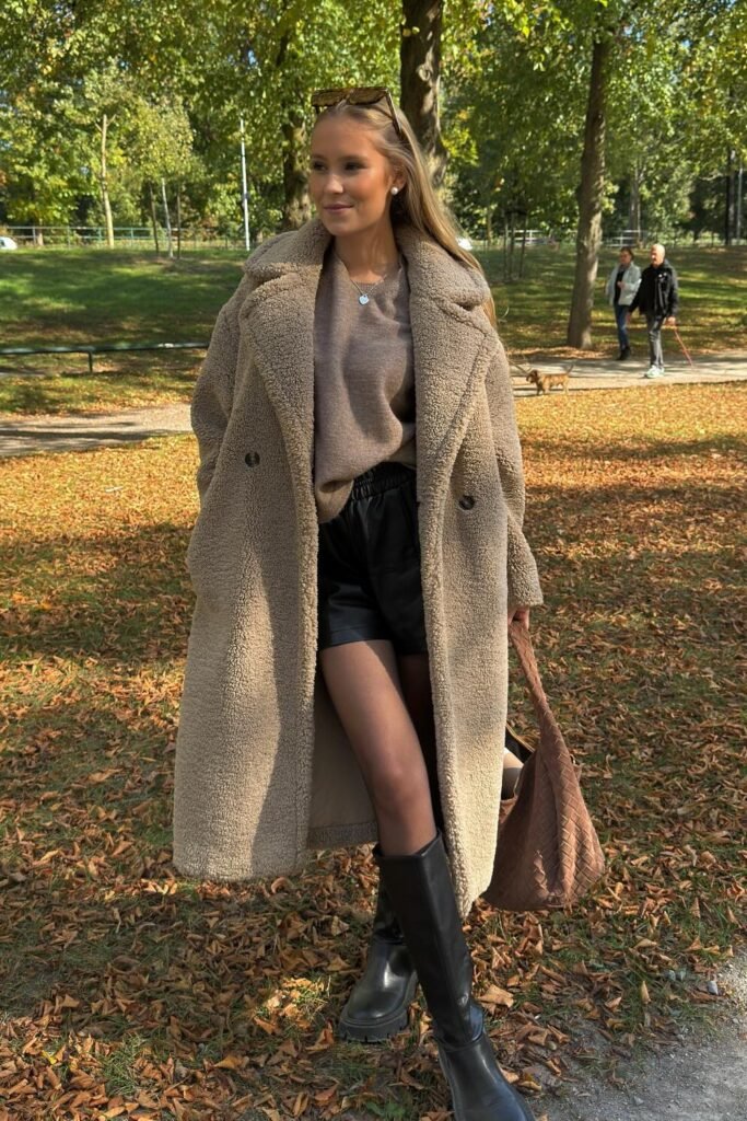 Teddy Bear Long Coat + Brown Crewneck Sweater + Black Faux Leather Shorts + Black Knee-High Boots