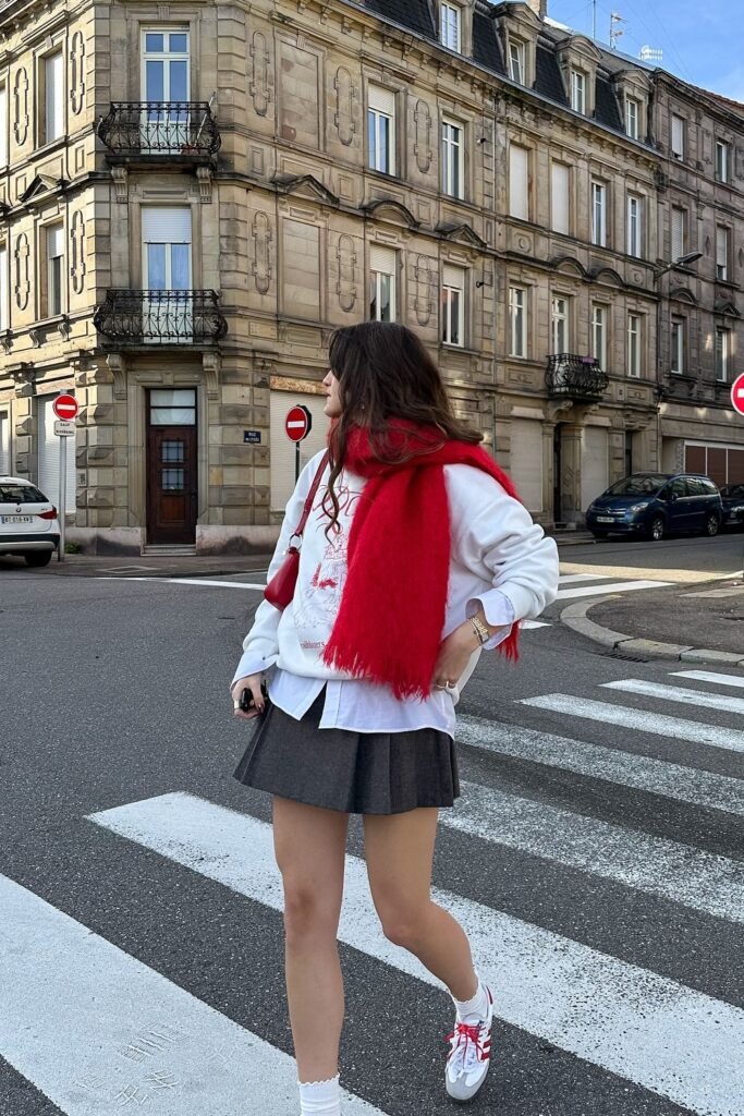 White Graphic Sweatshirt + White Button-Up Shirt + Grey Pleated Mini Skirt + Red Scarf + White Sneakers with Red Laces