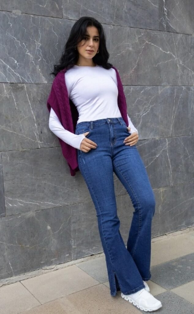 White Long-Sleeve Top + Purple Sweater (draped over shoulders) + Blue Split-Hem Flared Jeans + White Sneakers