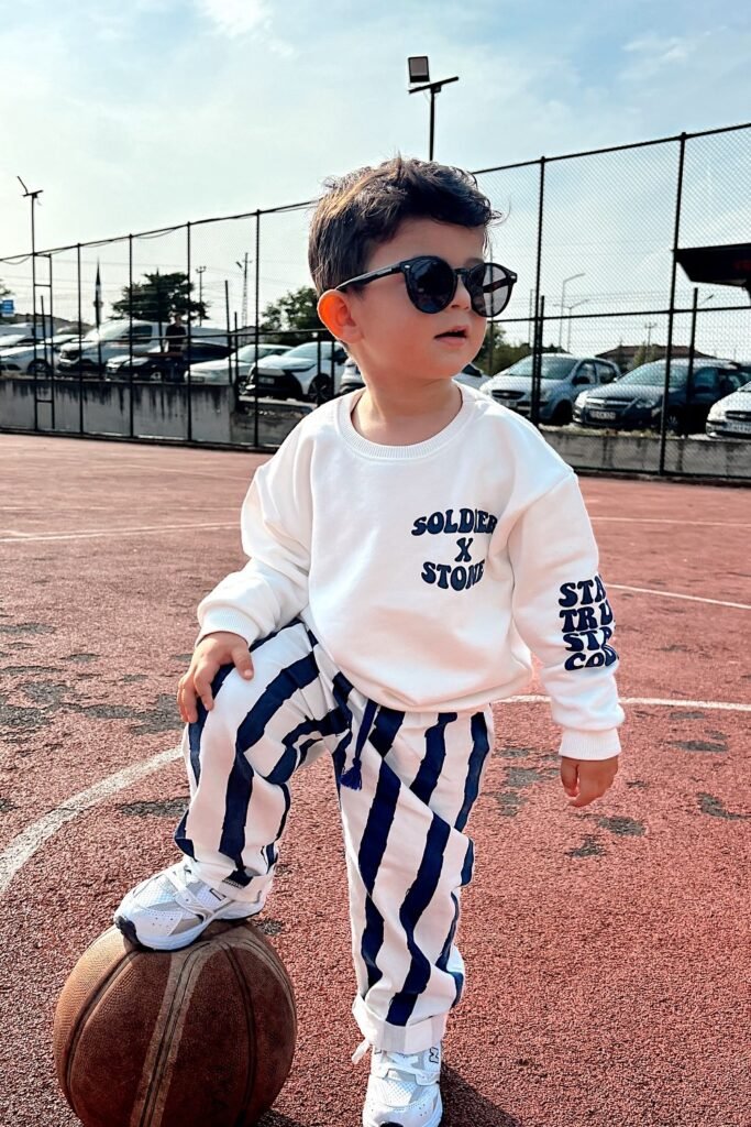 White Sweatshirt with Navy Prints + Striped Pants + White Sneakers + Sunglasses