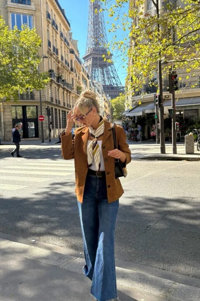 White T-shirt + Brown Blazer + Blue Flared Jeans + White and Brown Scarf + Black Handbag