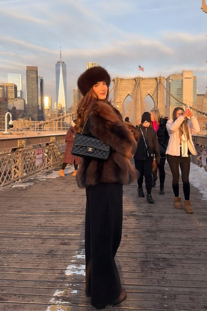 Brown Faux Fur Coat + Matching Fur Hat + Black Wide-Leg Trousers + Black Quilted Chain Bag