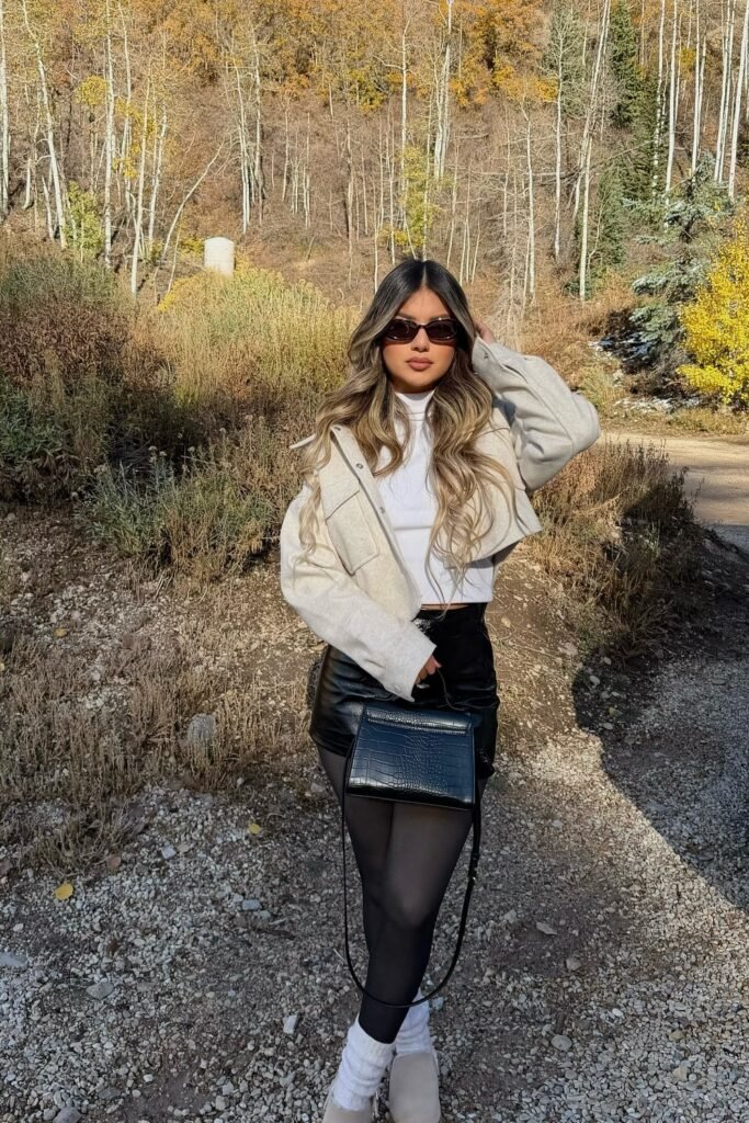 Cream Cropped Wool Jacket + White Turtleneck + Black Leather Mini Skirt + Black Tights + White Leg Warmers + Beige Mules