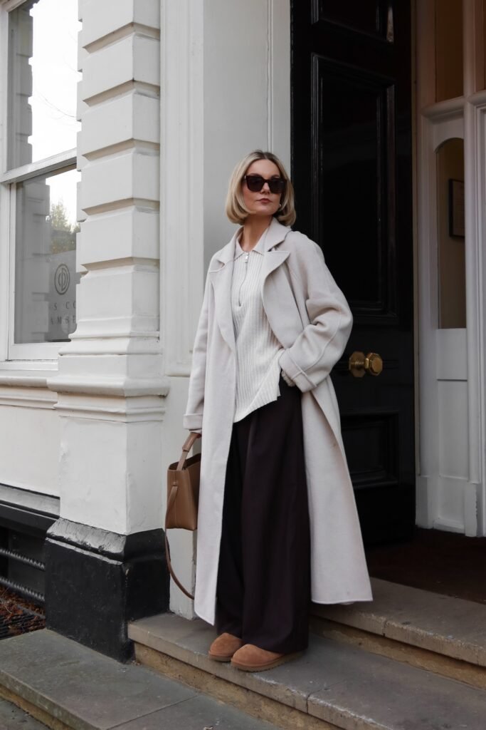 Cream Quarter-Zip Sweater + Dark Brown Wide-Leg Trousers + Oversized White Long Coat