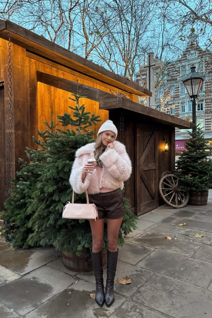 Light Pink Faux Fur Jacket + Brown Leather Shorts + Tall Black Boots + White Knit Beanie
