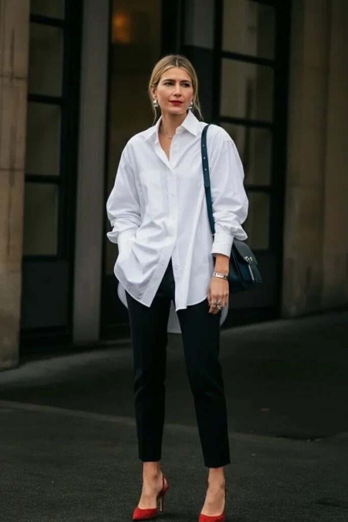 Oversized White Button-Down Shirt + Black Slim-Fit Trousers + Red Pointed-Toe Heels + Navy Shoulder Bag