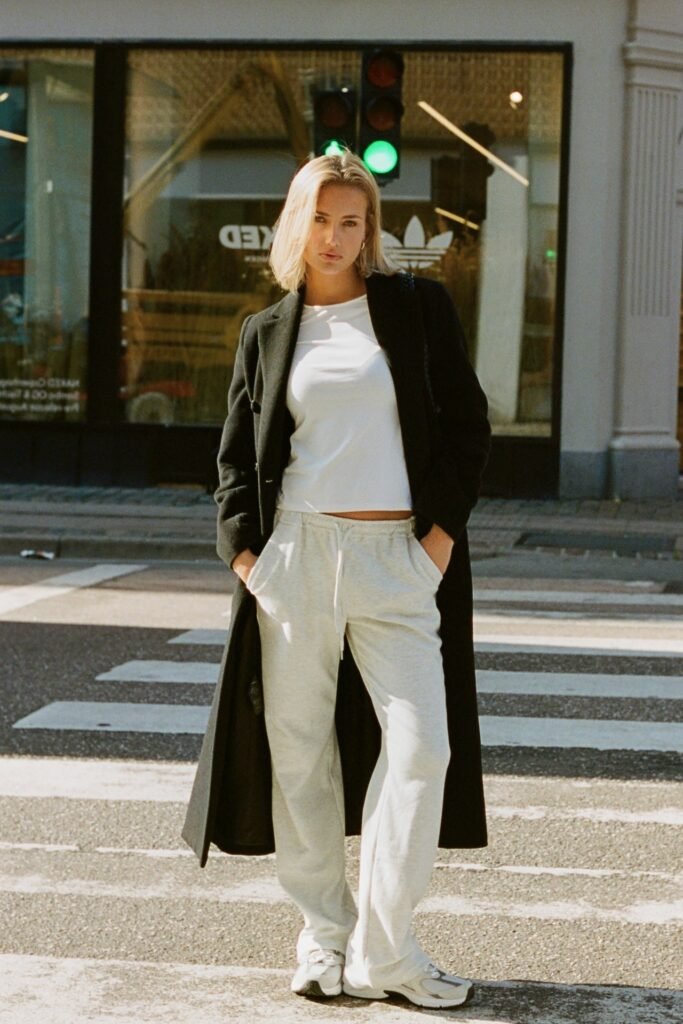White Crewneck T Shirt + Long Black Overcoat + Light Grey Sweatpants + White Trainers