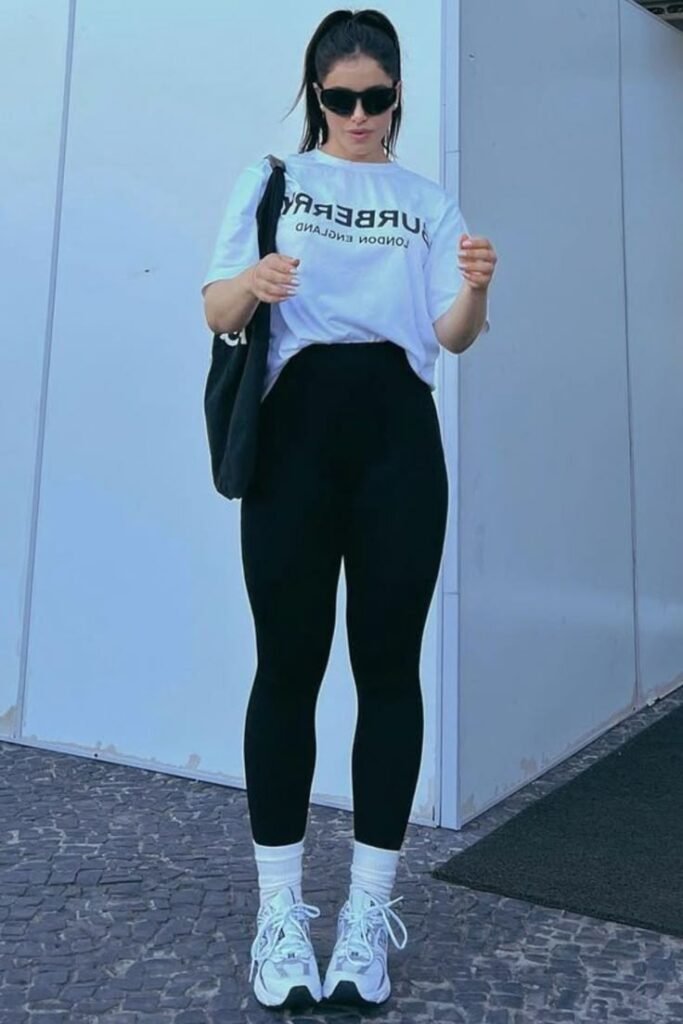 White Graphic T-Shirt + Black High-Waisted Leggings + White Crew Socks + White Athletic Sneakers