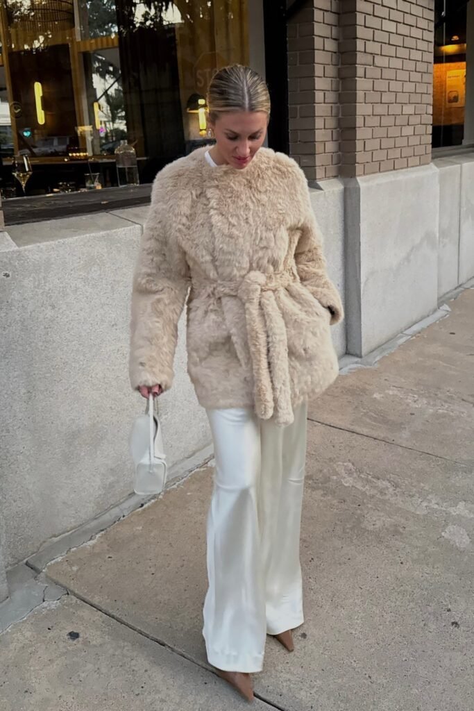 Beige Faux Fur Belted Coat + White Satin Wide-Leg Pants + Brown Pointed Boots + White Top Handle Bag