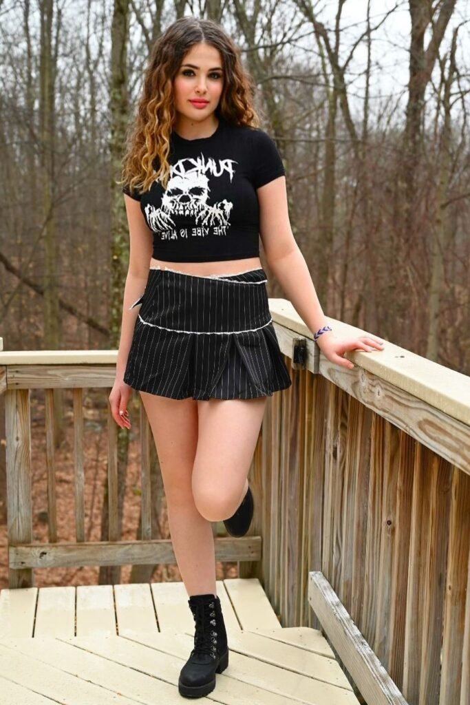 Black Graphic Crop Top + Black Pinstripe Pleated Mini Skirt + Black Lace-Up Combat Boots
