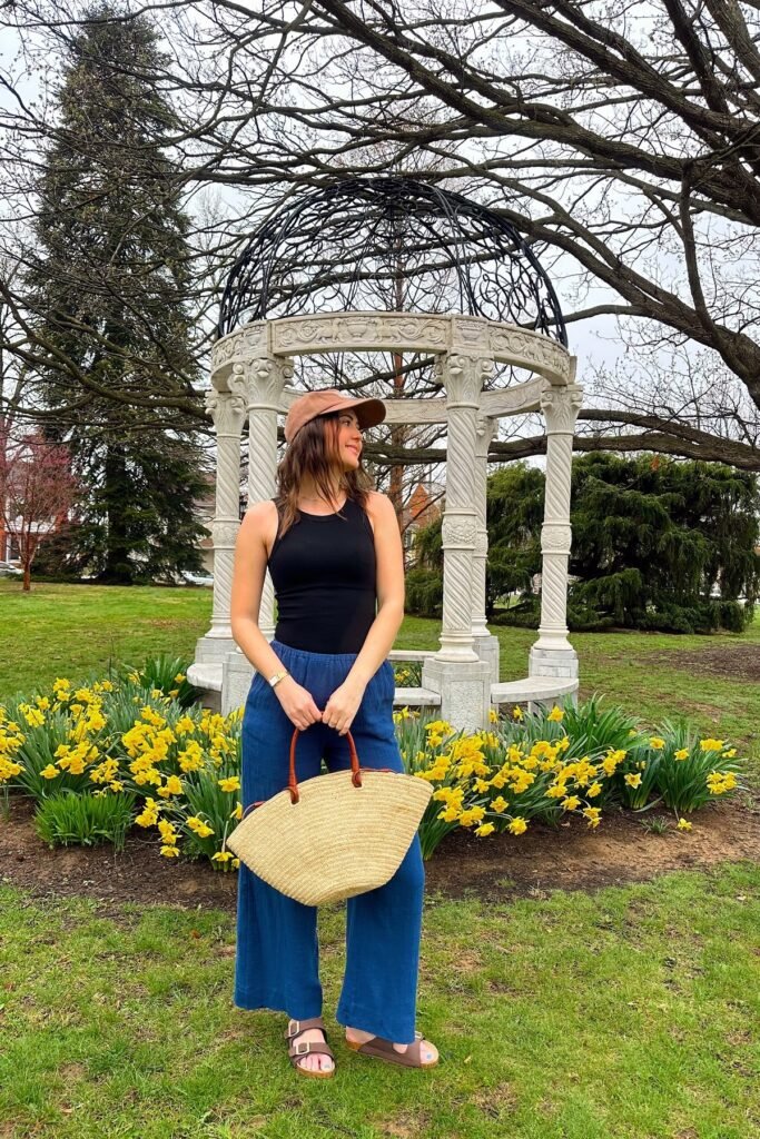 Black Ribbed Tank Top + Blue Wide-Leg Linen Trousers + Brown Strappy Sandals + Brown Baseball Cap