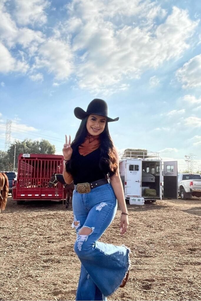 Black Sleeveless Bodysuit & Distressed Flare Jeans + Statement Buckle Belt + Brown Neck Scarf + Black Cowboy Hat